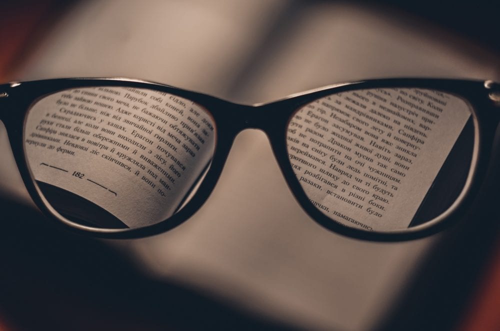 Vision glasses with book behind them