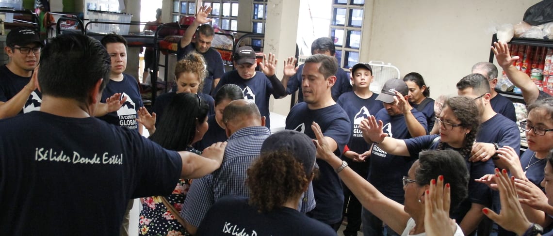 Volunteers in Guatemala praying over pastor and his wife after the volcano