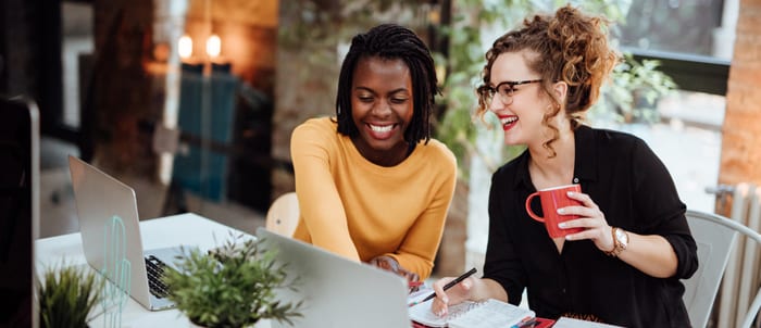 Two Businesswomen Working On Computer In Office