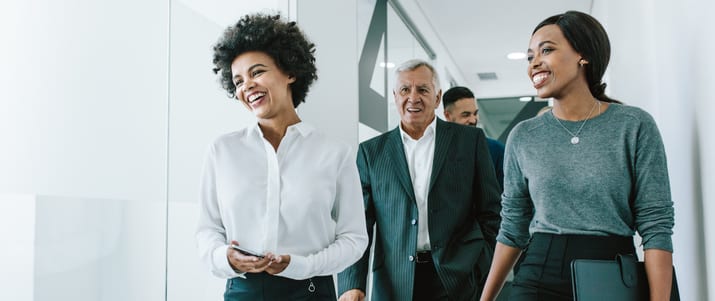 Group of business people walking through office corridor.