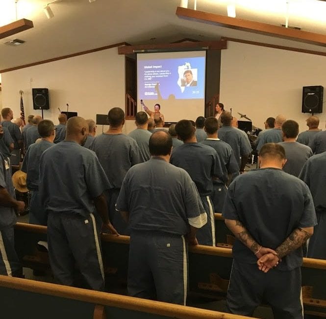 A group of inmates gather to watch and discuss GLS19.