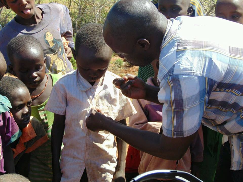 James Ouma sewing buttons for young boys