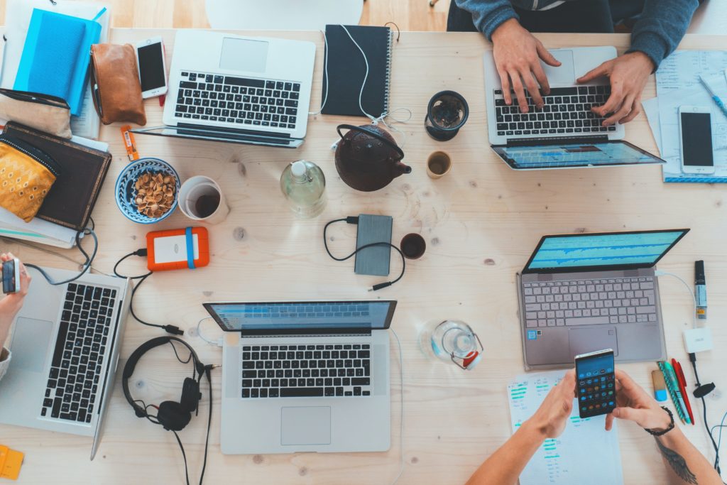 People sitting at a table online with their laptops