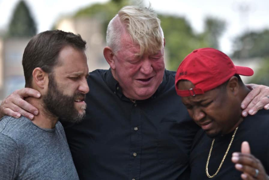 Bob Lenz embracing two people