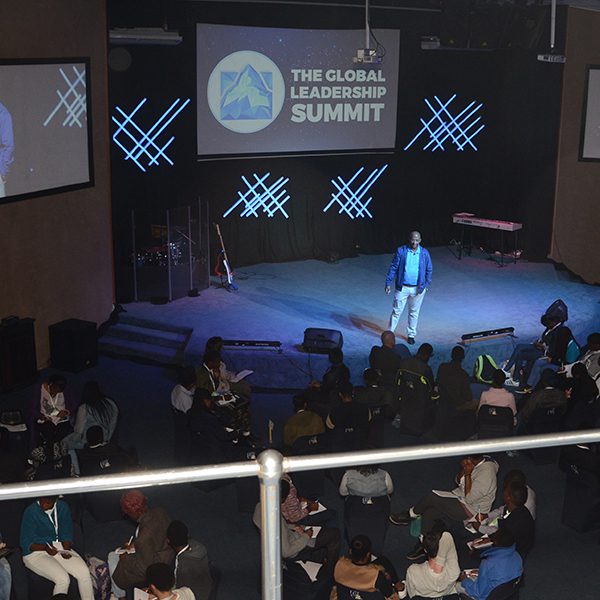 Man stands on stage speaking at a youth event in Swaziland in 2017.