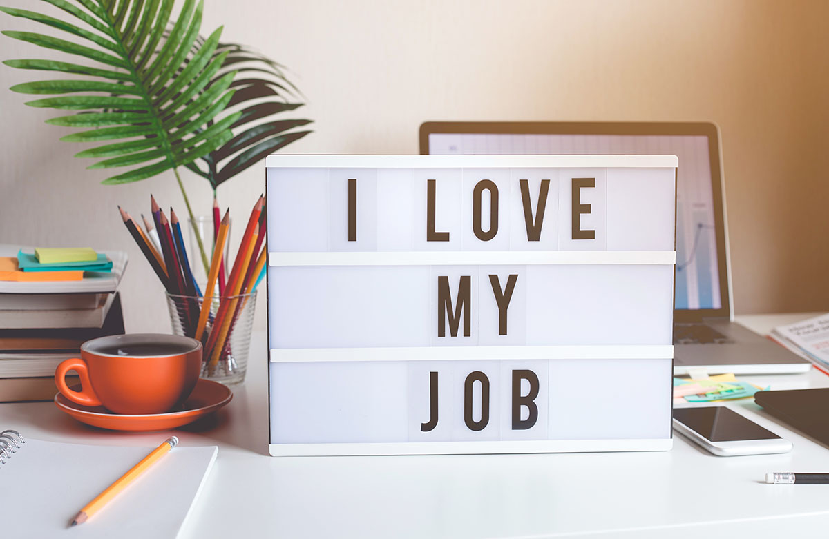 I love my job concepts with text on light box on desk table in home office